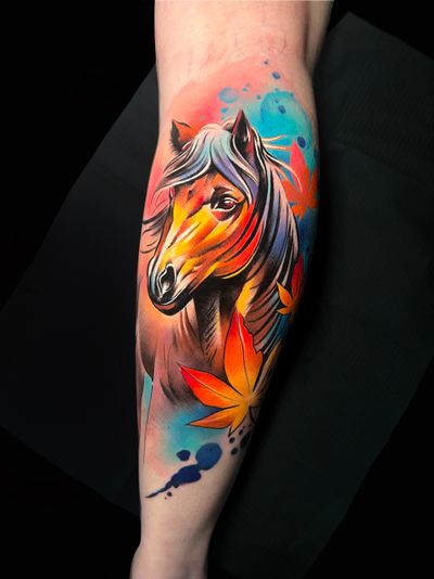 Express your free spirit with a stunning watercolor horse tattoo on your lower arm, by the talented artist Cloto.tattoos.