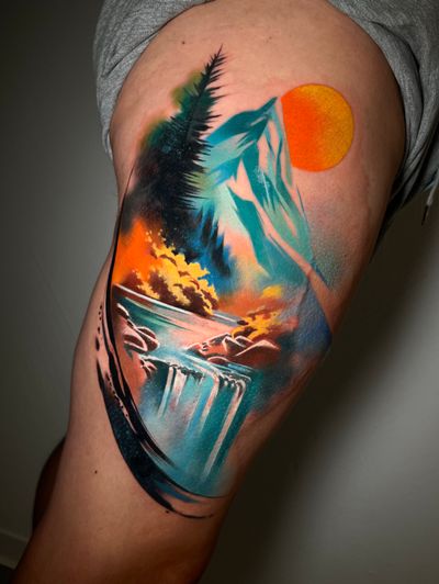 Experience the serene beauty of nature with this stunning watercolor thigh tattoo featuring mountains and a flowing river, by Cloto.tattoos.