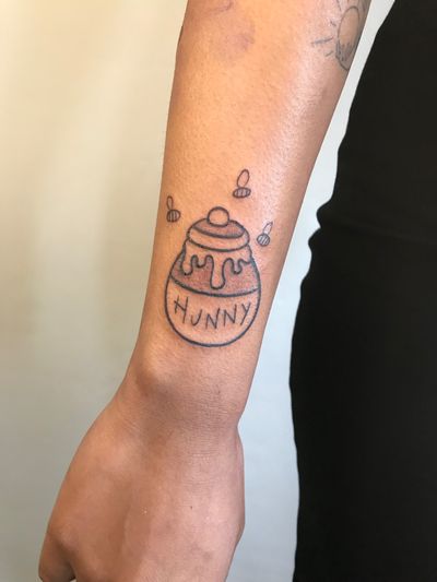 Unique illustrative tattoo by Jonathan Glick featuring a bee, honey pot, and Pooh the bear design. Perfect for fans of whimsical and charming artwork.