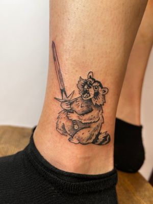 Ignite your rebellious spirit with this edgy illustrative tattoo by Jonathan Glick. A fierce raccoon brandishing a sword symbolizes strength and cunning.