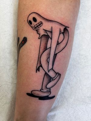 Get creeped out by Jonathan Glick's illustrative tattoo of a ghost hiding under a sheet with a mysterious rubber hose.