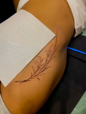 Elegant fine line flower tattoo on the hip, created by the talented artist Frankie Brown. Perfect for a subtle yet feminine touch.