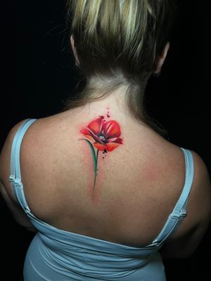 Adorn your upper back with a stunning watercolor flower tattoo by Cloto.tattoos. Exude elegance and beauty with this unique design.