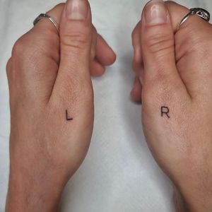 Elegantly designed small lettering tattoo by Jonathan Glick on the finger, perfect for a timeless look.