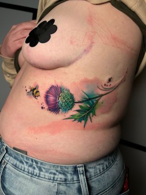 Get a stunning watercolor tattoo of a bee and flower on your ribs by Cloto.tattoos for a unique and beautiful look.