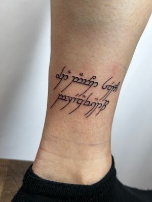 Elegant small lettering ankle tattoo by talented artist Jonathan Glick