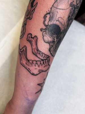 Get a jaw-dropping illustrative tattoo featuring a detailed skull with unique etching and woodcut design by renowned artist Jonathan Glick.