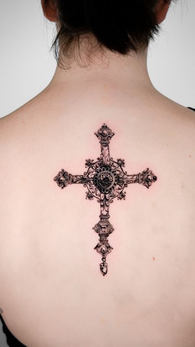 Get a stunning black and gray realism tattoo of a processional cross on your upper back by the talented artist Jacky Yang.