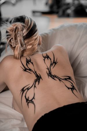 Elegant black and gray tattoo by Jacky Yang featuring a stunning pattern design on the back.
