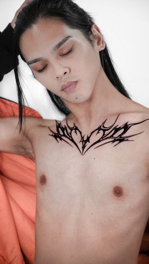 Discover the mesmerizing blend of black and gray in this chest tattoo by renowned artist Jacky Yang. A striking blackwork design that will surely turn heads.