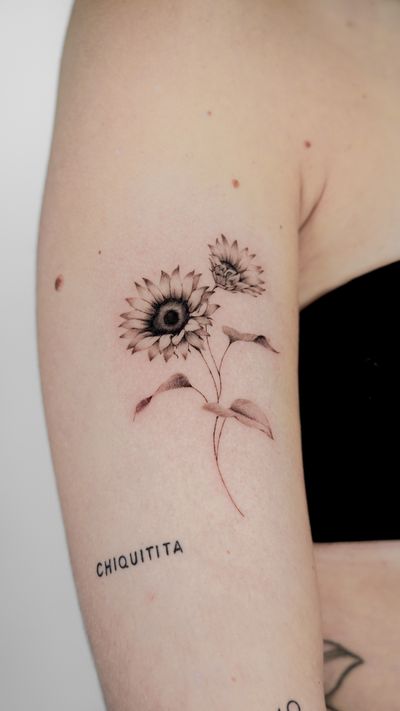 Elegant and intricate sunflower design on upper arm, crafted by renowned tattoo artist Jacky Yang.