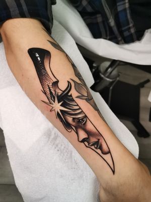 Capture the haunting beauty of a knife and face in this stunning neo-traditional lower arm tattoo by Yaia_ink.