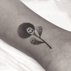 Unique dotwork and ignorant style tattoo featuring an abstract plant branch and smiley face design by Oliver Whiting.