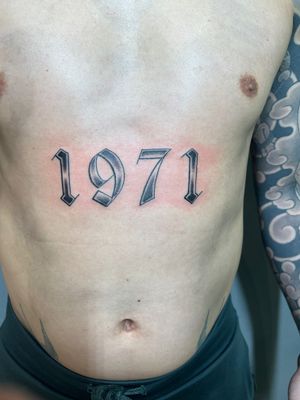 Celebrate special moments with Clayton Jeremiah's exquisite lettering tattoo design of a significant date.