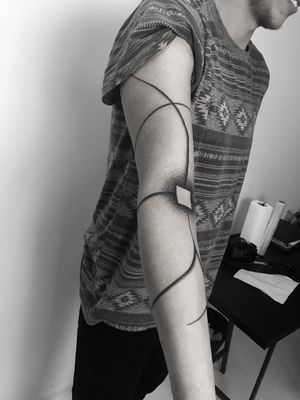 Express your individuality with a striking abstract blackwork and dotwork tattoo done by the talented artist Oliver Whiting.