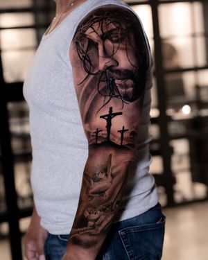 Experience the divine with Abel Lopez's exquisite tattoo showcasing a realistic black and gray design of Jesus on the cross.