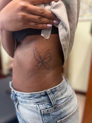 Elegant and intricate butterfly tattoo designed for dark skin tones, created with skillful fine line and illustrative techniques by Clayton Jeremiah.