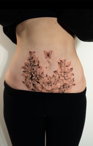 Elegant floral motif tattoo on stomach by talented artist Ion Caraman, bringing natural beauty and grace to your body.