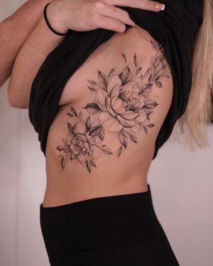 Adorn your ribs with a stunning flower motif in a delicate floral style by the talented artist Ion Caraman.