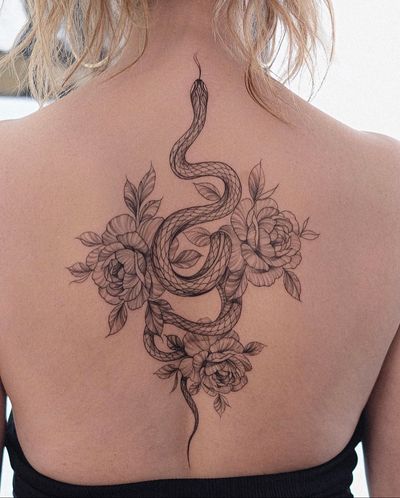 Fine line floral tattoo by Ion Caraman featuring a beautiful snake and peony motif.