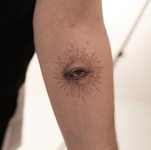 Experience the detailed artistry of Ion Caraman with this stunning micro realism tattoo featuring an eye shedding a tear, perfect for your forearm.