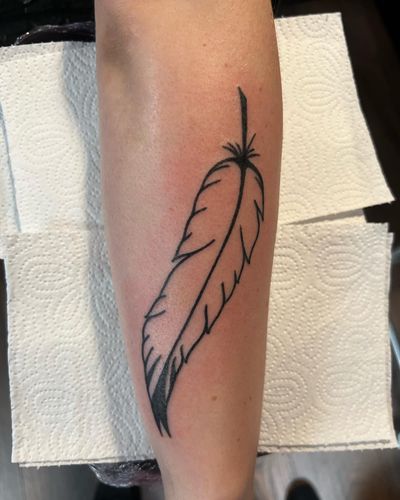 Detailed illustrative tattoo of a delicate feather by artist Rasmus Bang.