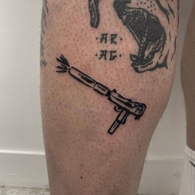 Get inked with a powerful uzi gun design by the talented artist Charlie Macarthur. This illustrative tattoo is sure to make a statement.
