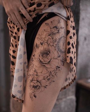 Adorn your thigh with a stunning floral design by Ion Caraman, featuring intricate flower motifs. Perfect for a unique and feminine touch.