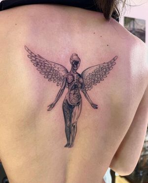 Capture the ethereal beauty of Nirvana with this fine line angel tattoo by Ion Caraman. In utero symbolism adds depth to this illustrative design.