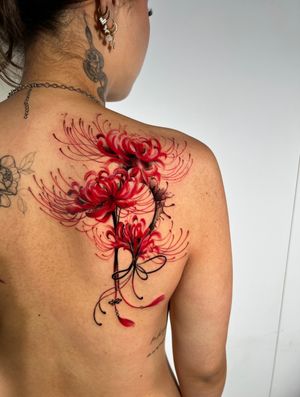 Vibrant and detailed illustrative tattoo of a spider lily flower by Ion Caraman. Get the perfect blend of elegance and edge!