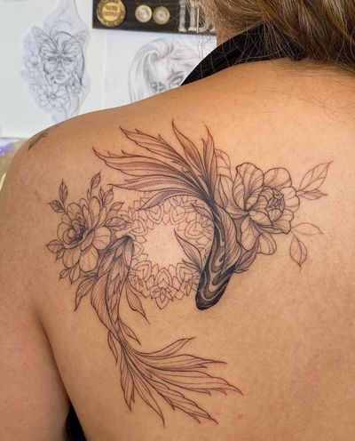 Get inked by Ion Caraman with a stunning fusion of fine line, geometric details featuring a fish and a flower motif in a ying yang composition.