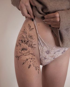 Elegant flower tattoo on the hip, expertly done by Ion Caraman. A beautiful and feminine design.