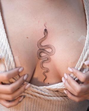 This unique tattoo combines dotwork and fine line techniques to create a stunning illustrative snake design by the talented artist Ion Caraman.