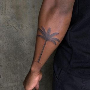 Experience the beauty of nature with this stunning illustrative palm tree tattoo, expertly done on dark skin by Charlie Macarthur.