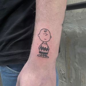 Capture the classic charm of Charles Schulz's characters with this whimsical tattoo by artist Charlie Macarthur.