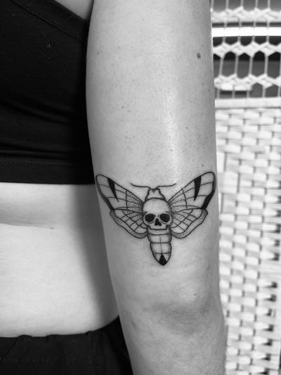 Embrace the beauty of death with this intricate dotwork design featuring a moth and skull, expertly done by artist Claudia Vicente.
