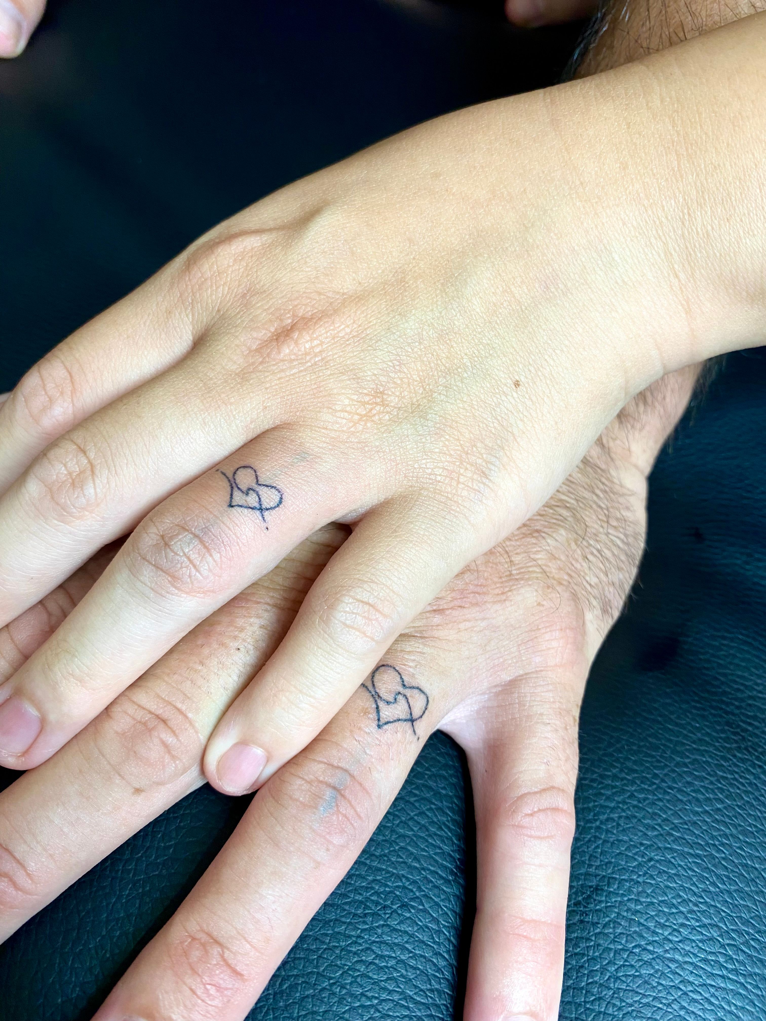 Minimalist infinity symbol tattoo on the finger.