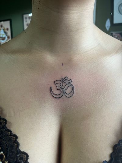 Experience tranquility with this intricately detailed fine line Ohm symbol tattoo by Claudia Vicente.