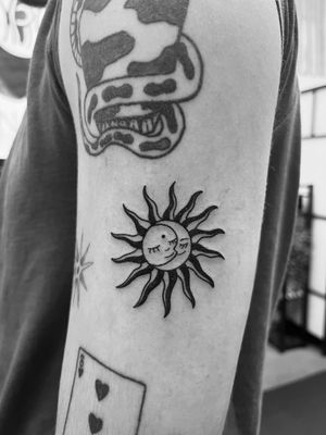 This illustrative tattoo features a sun and moon motif in a unique patchwork style, created by the talented artist Claudia Vicente.