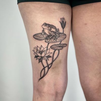Immerse yourself in a serene pond with this stunning tattoo featuring a frog, lotus, and water lily. Let Paula bring this beautiful design to life on your skin.