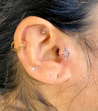 Get a touch of ignorance with this star motif ear tattoo by Charlotte Pokes, adding a spark of personality to your look.