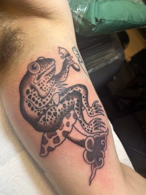 A traditional Japanese tattoo of a frog and mushroom, expertly designed by Claudia Vicente with intricate details and vibrant colors.
