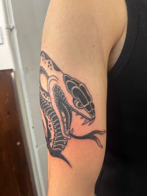Get inked with this bold and timeless illustrative snake design by the talented artist Claudia Vicente.