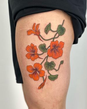 Get inked by Paula with a stunning floral design featuring detailed nasturtium flowers and botanical elements.
