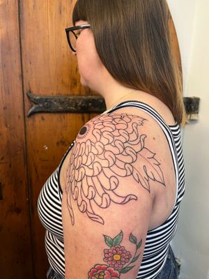 Experience the artistry of Claudia Vicente with this stunning Japanese chrysanthemum tattoo. The intricate details and illustrative style will surely make a statement.