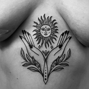 Unique dotwork tattoo featuring a medieval sun design with hands holding a branch, created by the talented artist Claudia Vicente.