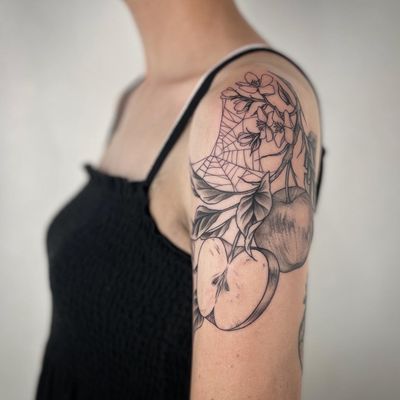 Capture the beauty of nature with this unique tattoo featuring a delicate flower, juicy fruit, and intricate spider web. Created by the talented artist, Paula.
