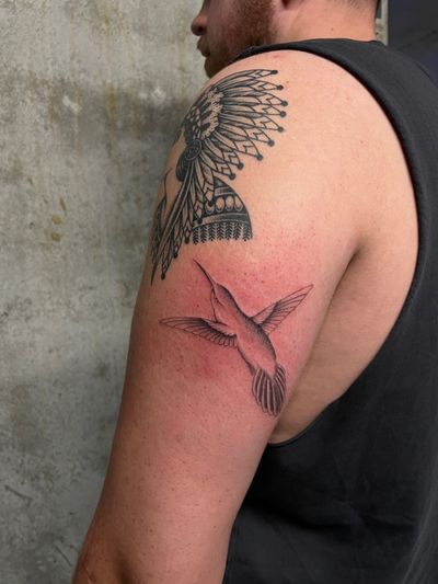Admire the delicate beauty of this dotwork and illustrative style hummingbird tattoo by renowned artist Rich Sinner.