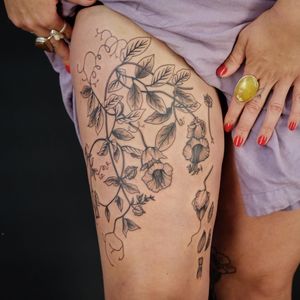 Paula's illustrative tattoo features a beautiful botanical motif with flowers, branches, and leaves.
