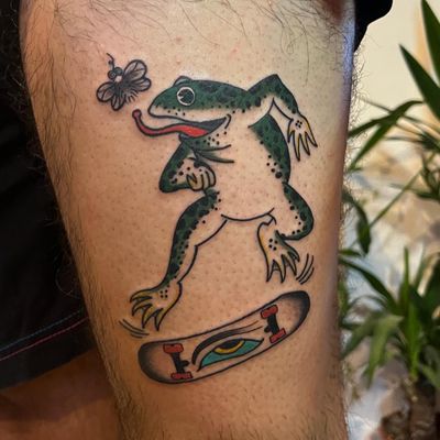 Experience traditional Japanese art with a unique twist, featuring a frog on a skateboard jumping over a fly in this stunning tattoo by Claudia Vicente.